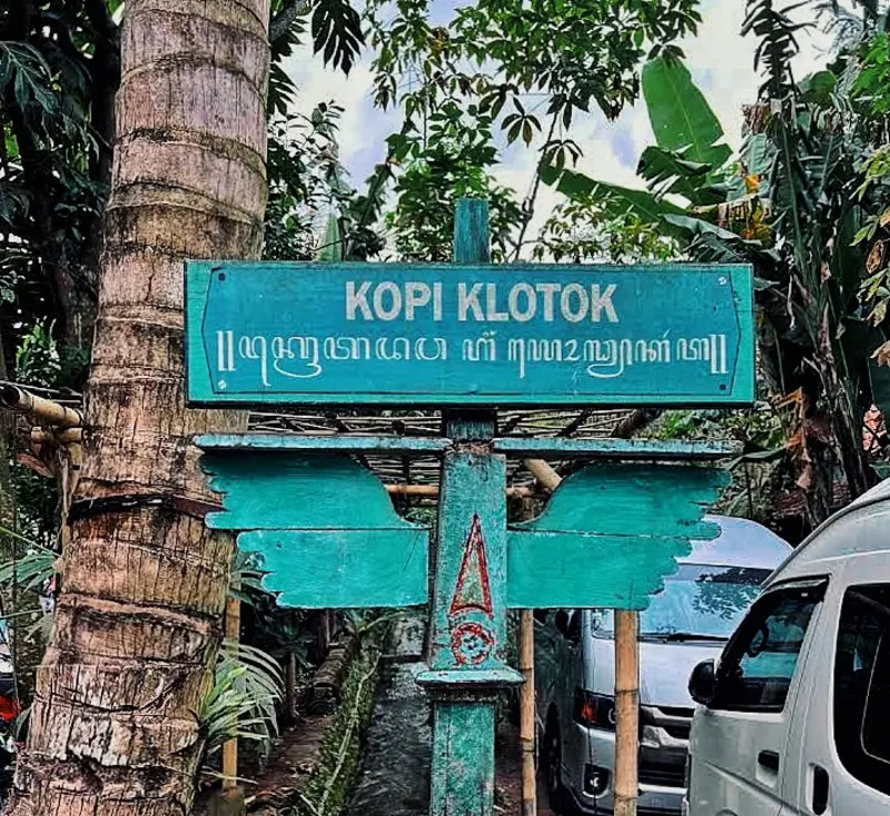 Kopi Klotok dengan bangunan sederhana dan pemandangan sawah dan Gunung Merapi.