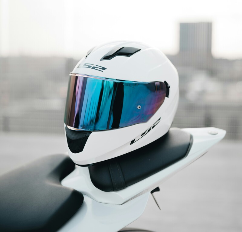 Dua helm SNI bersih berwarna senada diletakkan di spion motor