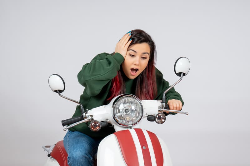 Wisatawan menggunakan helm bersiap mengendarai motor sewaan di Solo sebagai ilustrasi syarat sewa motor.