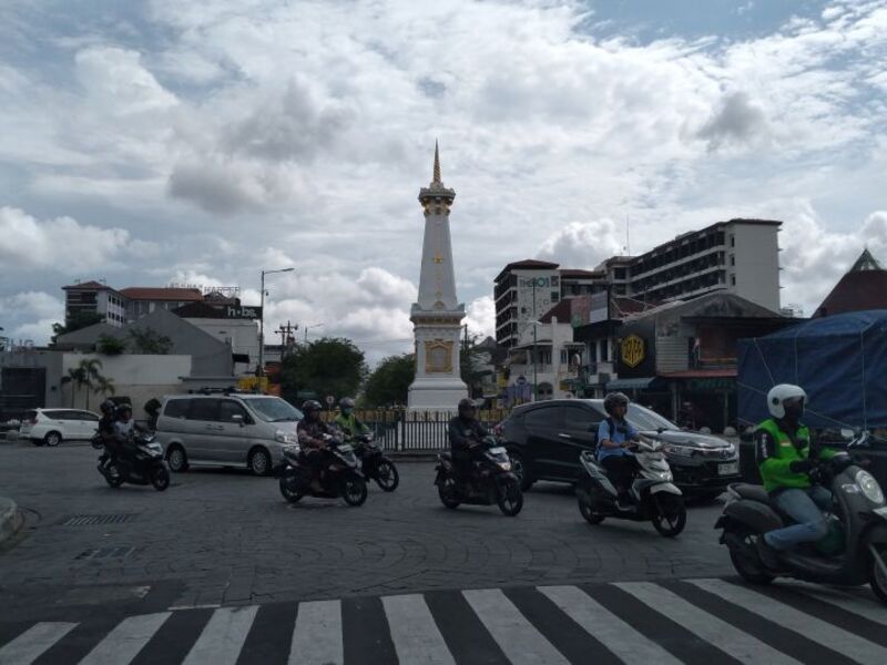 Pengendara motor menggunakan helm SNI melewati kawasan Tugu Jogja