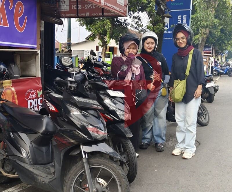 Petugas rental motor menyerahkan kunci kepada wisatawan di depan gerbang Stasiun Lempuyangan